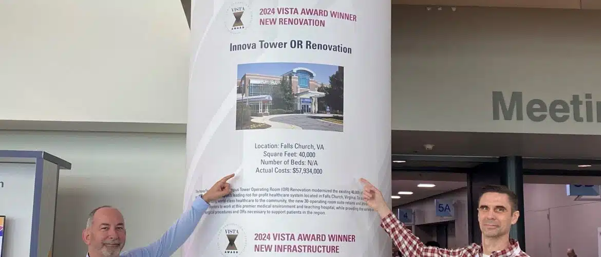 2 men pointing at award banner