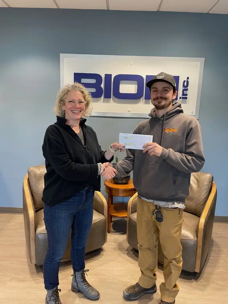 man and women shaking hands holding letter